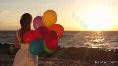 迷人的金发女人与惊人的金色长发在风中飘扬，拿着五颜六色的气球，在海边度过了美好的时光
